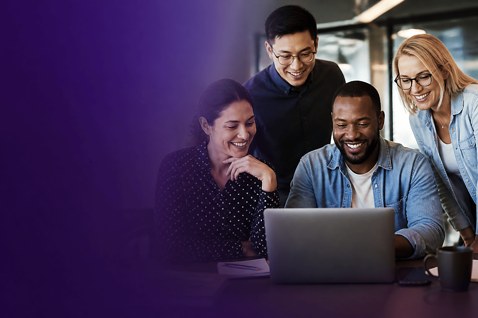 Team collaborating around a laptop